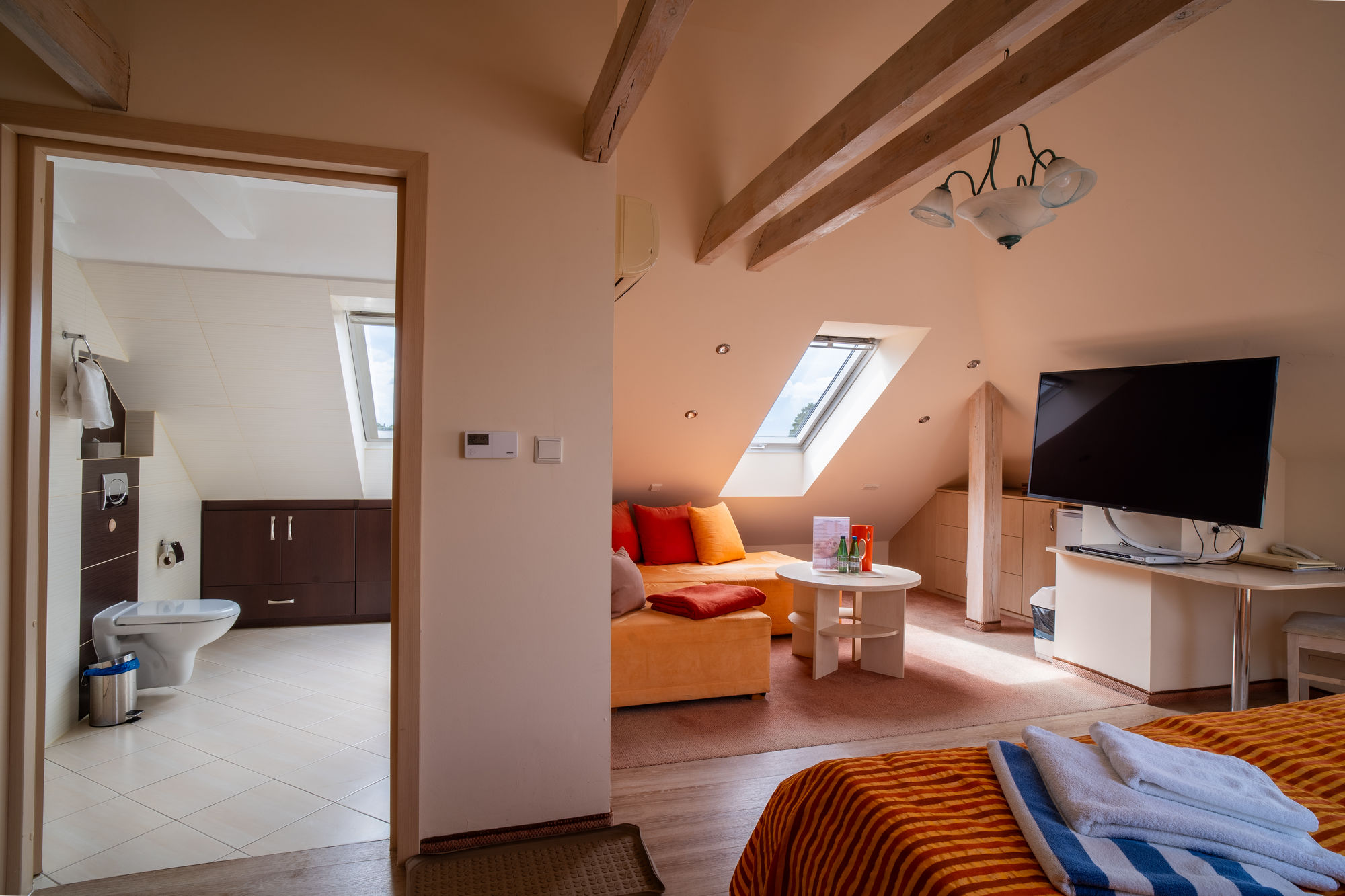 Przytulny apartament na poddaszu z salonem, sypialnią, łazienką i drewnianymi belkami